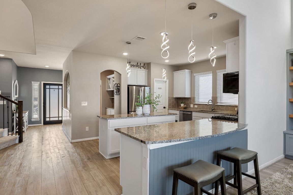 408 Ravello Street Liberty Hill, TX 78642 - Photo 8 of 40 a large kitchen with granite countertop a large counter top appliances and cabinets