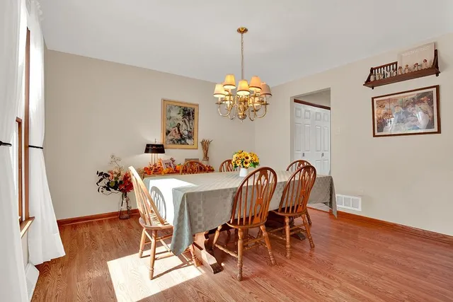 a dining room with furniture wooden floor a rug and a chandelier