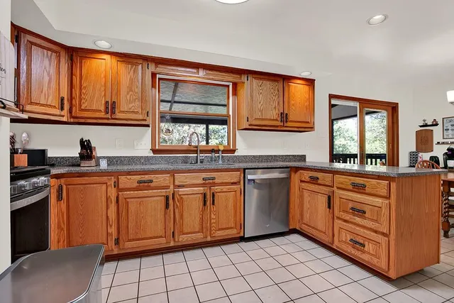 a kitchen with stainless steel appliances granite countertop a sink stove and cabinets