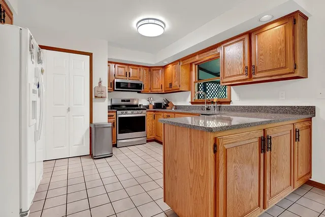 a kitchen with stainless steel appliances granite countertop a refrigerator and a stove top oven