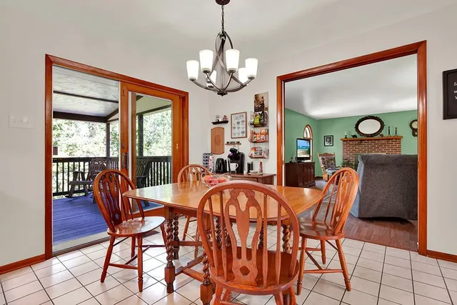 a dining room with furniture a chandelier and wooden floor
