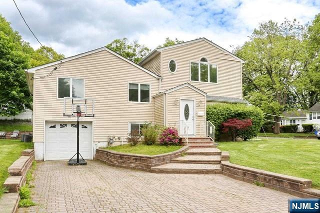 84 12th Street Cresskill, NJ 07626 - Photo 1 of 45 a front view of a house with a yard and garage