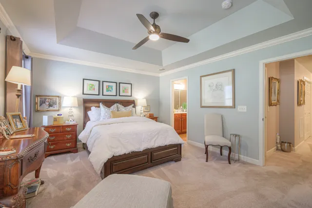 a bedroom with a bed lamps and a chandelier