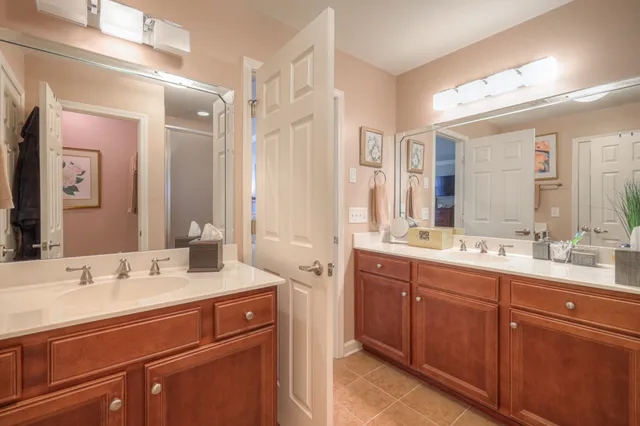 a bathroom with a sink double vanity granite tub shower and a mirror