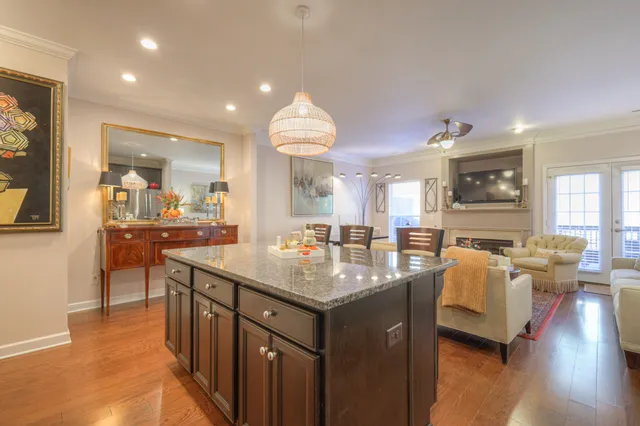a dining hall with stainless steel appliances granite countertop a living room dining room and kitchen view