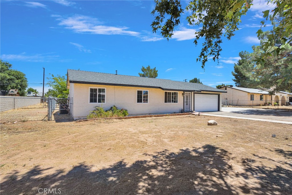 15471 Washoan Road Apple Valley, CA 92307 - Photo 4 of 38 a front view of a house with a yard covered with snow and trees