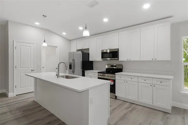 a kitchen with stainless steel appliances kitchen island a refrigerator sink and microwave