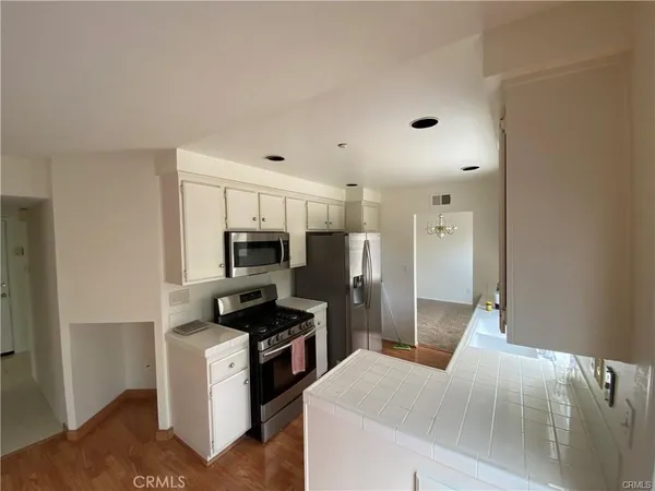 a kitchen with stainless steel appliances a refrigerator and a stove top oven