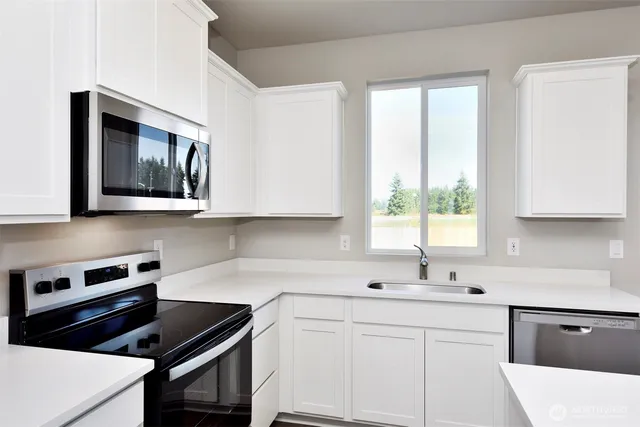 a kitchen with appliances cabinets and a window