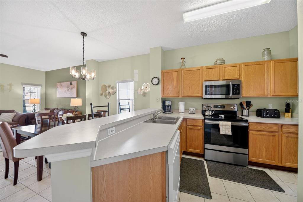 8538 Crystal Cove Loop Kissimmee, FL 34747 - Photo 12 of 59 a kitchen with stainless steel appliances granite countertop a sink a stove top oven a counter space and cabinets