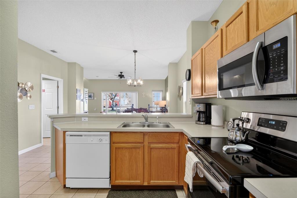 8538 Crystal Cove Loop Kissimmee, FL 34747 - Photo 13 of 59 a kitchen with stainless steel appliances granite countertop a stove and a sink