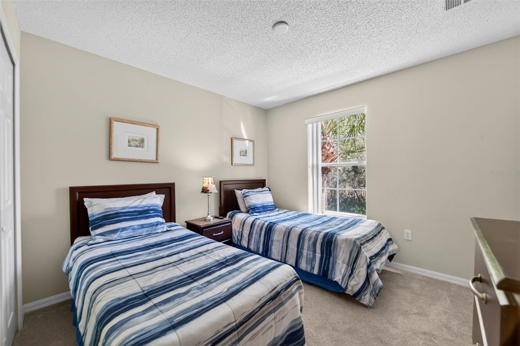 8538 Crystal Cove Loop Kissimmee, FL 34747 - Photo 22 of 59 a bedroom with two beds and a large window