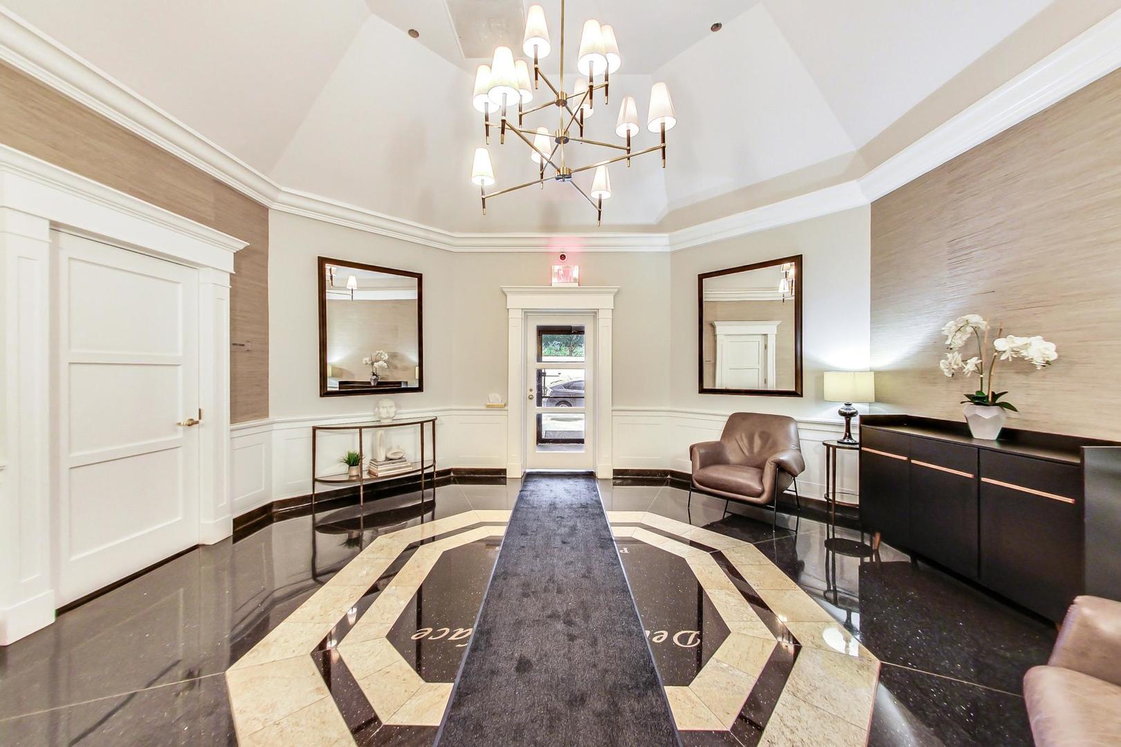 33 West Delaware Place, Unit 12K Chicago, IL 60610 - Photo 18 of 21 a large bedroom with wooden floor and chandelier