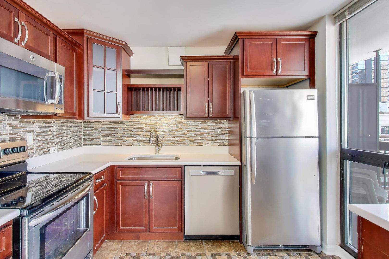 33 West Delaware Place, Unit 12K Chicago, IL 60610 - Photo 7 of 21 a kitchen with stainless steel appliances granite countertop a refrigerator a stove a sink and a microwave