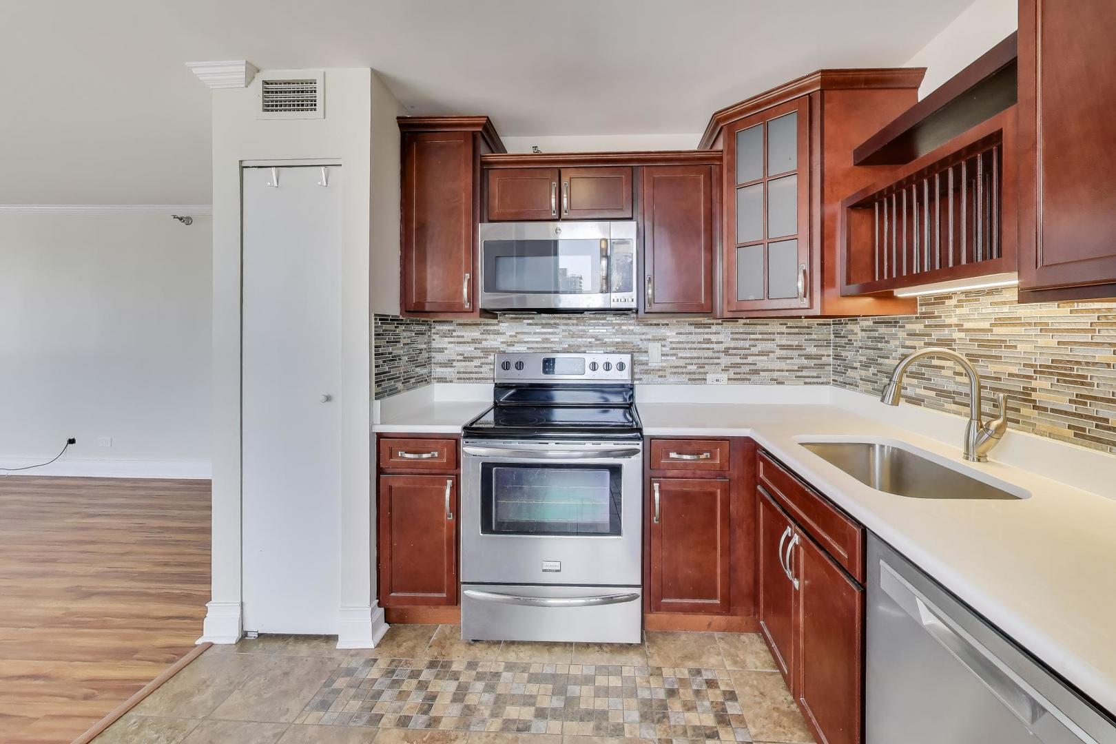 33 West Delaware Place, Unit 12K Chicago, IL 60610 - Photo 8 of 21 a kitchen with stainless steel appliances granite countertop a sink stove and refrigerator