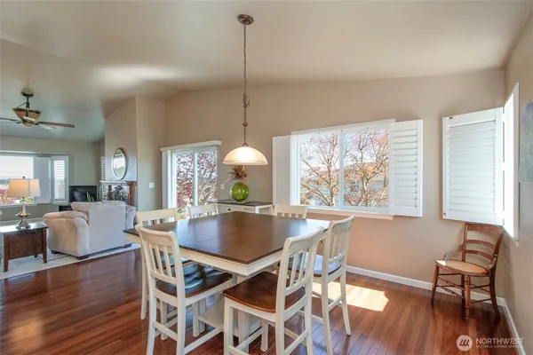 a dining room with furniture a chandelier and wooden floor