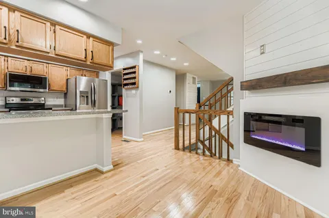 a open kitchen with stainless steel appliances granite countertop a refrigerator stove top oven and sink with wooden floor