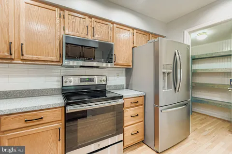 a kitchen with granite countertop a refrigerator stove and microwave