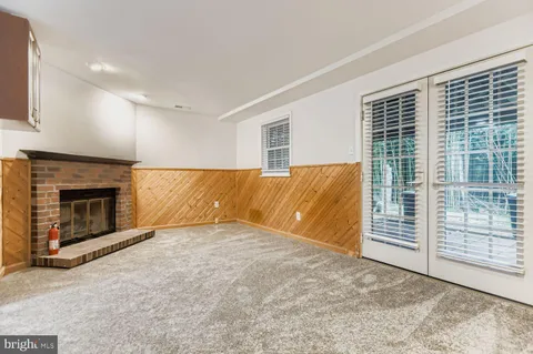 a view of an empty room with a fireplace and a window