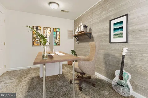 a view of a workspace with furniture and a window