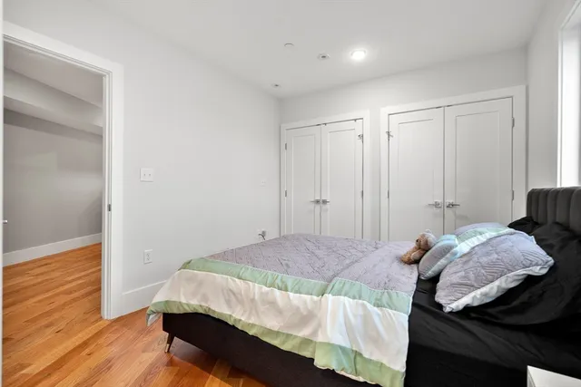 a bedroom with a bed and wooden floor