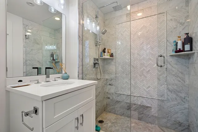 a bathroom with a sink shower and a mirror