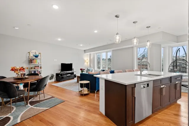 a kitchen island with granite countertop a sink and chairs