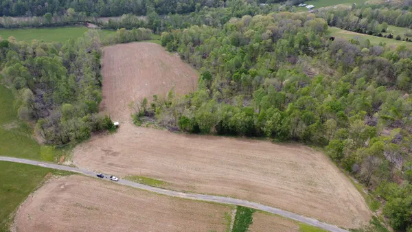 an aerial view of a house with a yard and lake view