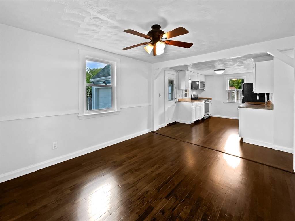 444 Lowell Street Reading, MA 01867 - Photo 12 of 38 a view of a livingroom with wooden floor and a ceiling fan