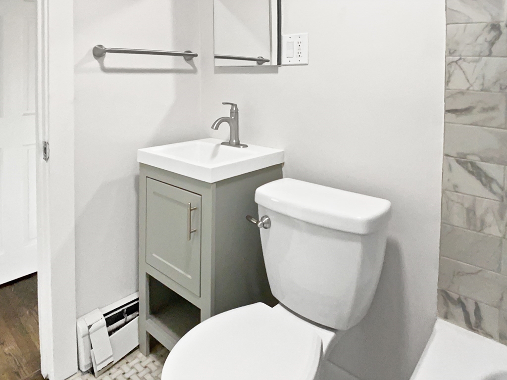 444 Lowell Street Reading, MA 01867 - Photo 13 of 38 a white toilet sitting next to a bathroom sink