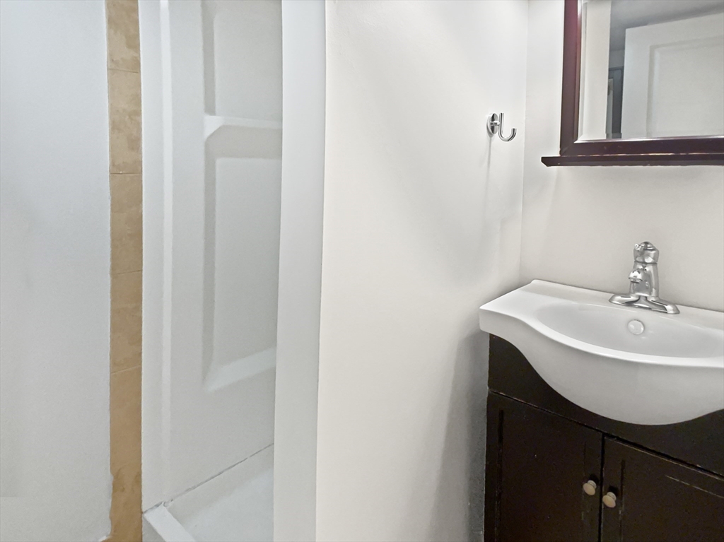 444 Lowell Street Reading, MA 01867 - Photo 14 of 38 a bathroom with a sink a mirror and a toilet