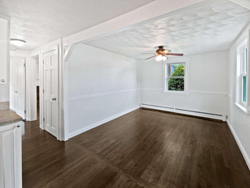 444 Lowell Street Reading, MA 01867 - Photo 17 of 38 an empty room with wooden floor and windows