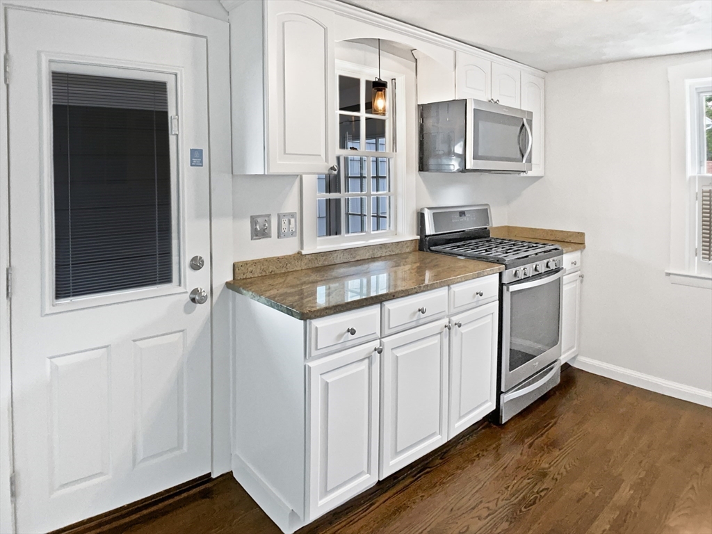 444 Lowell Street Reading, MA 01867 - Photo 18 of 38 a kitchen with stainless steel appliances granite countertop a stove and a microwave