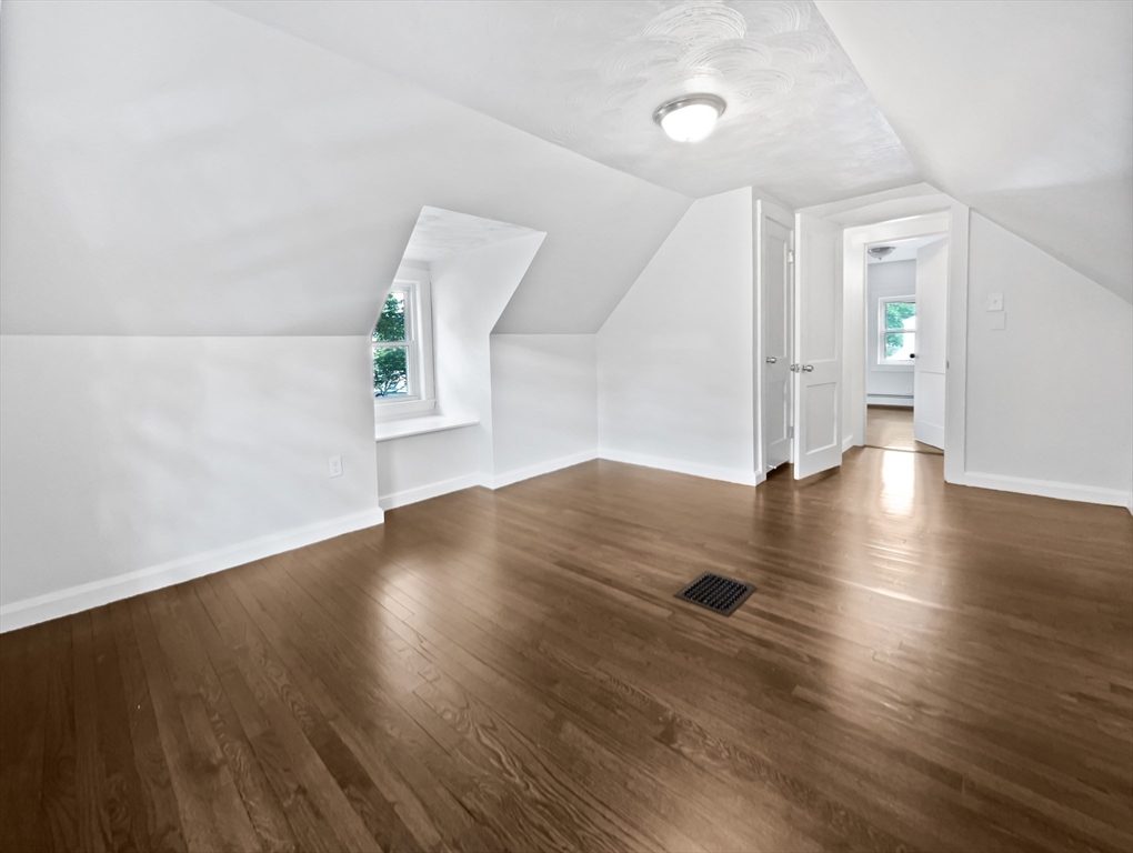444 Lowell Street Reading, MA 01867 - Photo 21 of 38 an empty room with wooden floor and windows