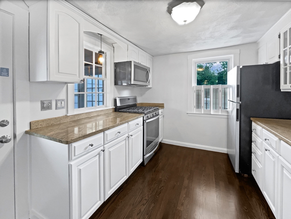 444 Lowell Street Reading, MA 01867 - Photo 24 of 38 a kitchen with granite countertop a sink stove and cabinets