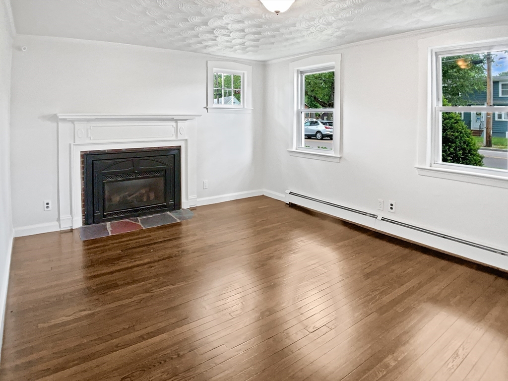 444 Lowell Street Reading, MA 01867 - Photo 26 of 38 wooden floor fireplace and windows in an empty room