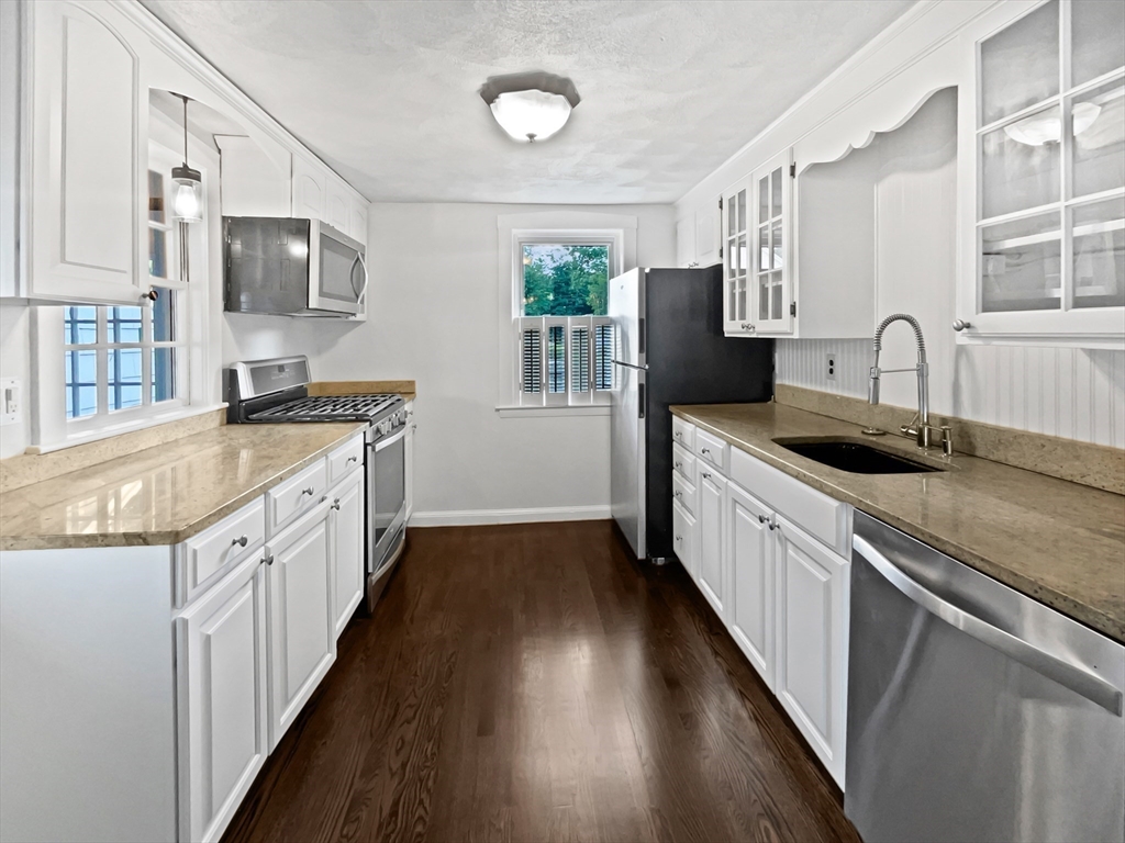 444 Lowell Street Reading, MA 01867 - Photo 28 of 38 a kitchen with stainless steel appliances granite countertop a sink stove and refrigerator