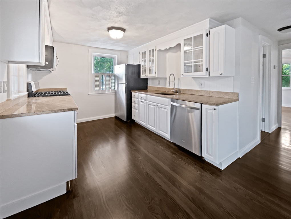 444 Lowell Street Reading, MA 01867 - Photo 30 of 38 a kitchen with stainless steel appliances granite countertop a sink a stove a refrigerator and cabinets