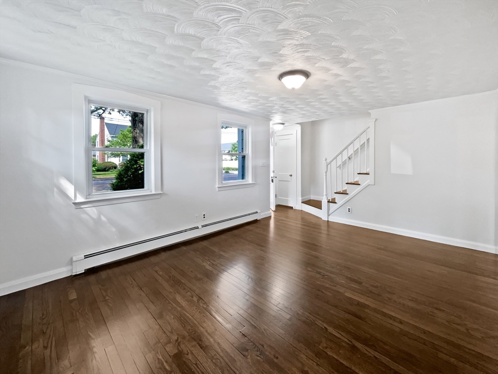 444 Lowell Street Reading, MA 01867 - Photo 3 of 38 an empty room with wooden floor and windows