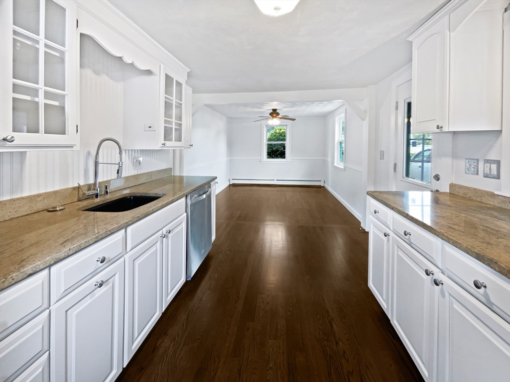 444 Lowell Street Reading, MA 01867 - Photo 31 of 38 a large kitchen with granite countertop stove a sink and dishwasher with wooden floor
