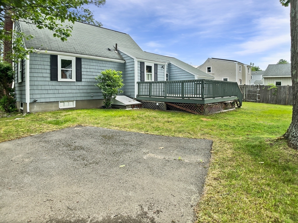 444 Lowell Street Reading, MA 01867 - Photo 9 of 38 a front view of house with yard and garage