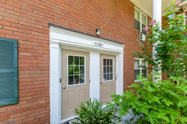 a view of a brick house with potted plants