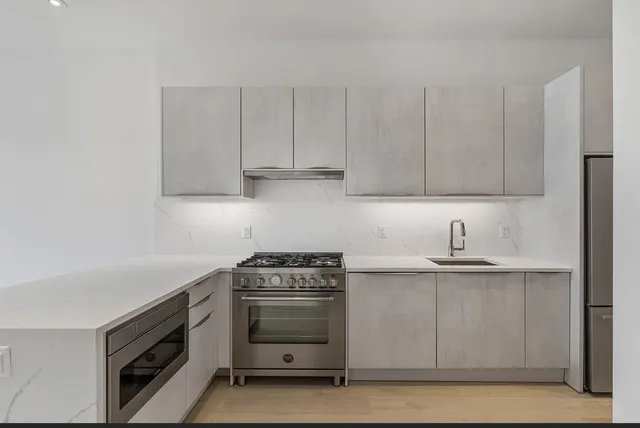 a kitchen with stainless steel appliances granite countertop a sink stove and cabinets