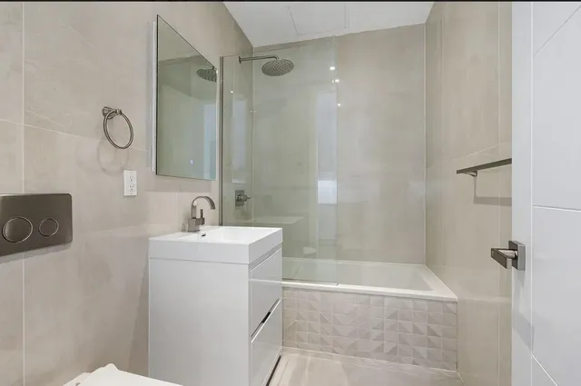 a bathroom with a sink a toilet a mirror and shower