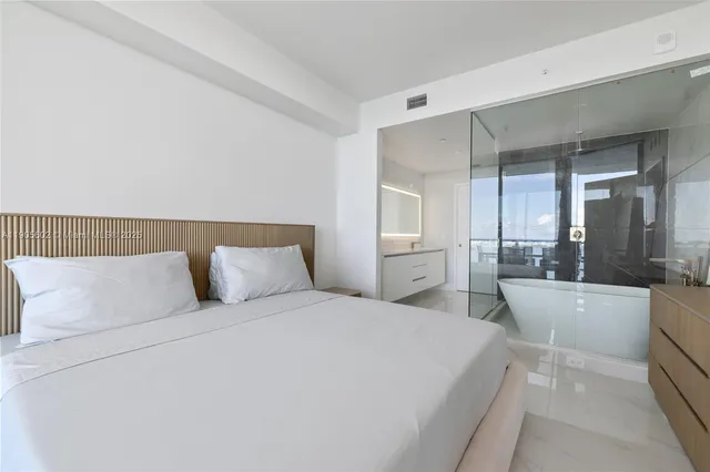 a spacious bedroom with a large bed and a dresser