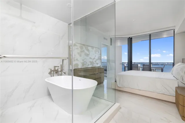 a spacious bathroom with a bathtub a double vanity sink and mirror