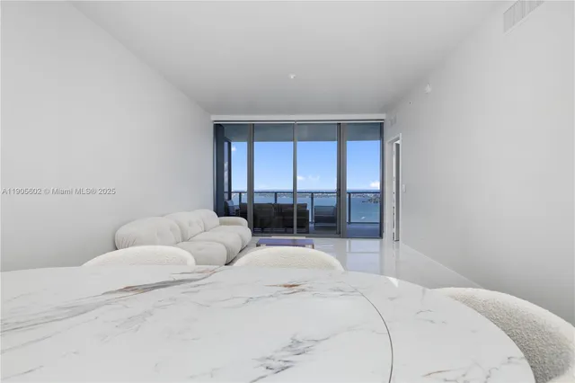 a living room with furniture and large glass door