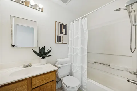 a bathroom with a granite countertop sink toilet a mirror and shower