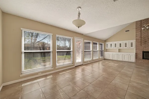 a view of an empty room with wooden floor and a ceiling fan