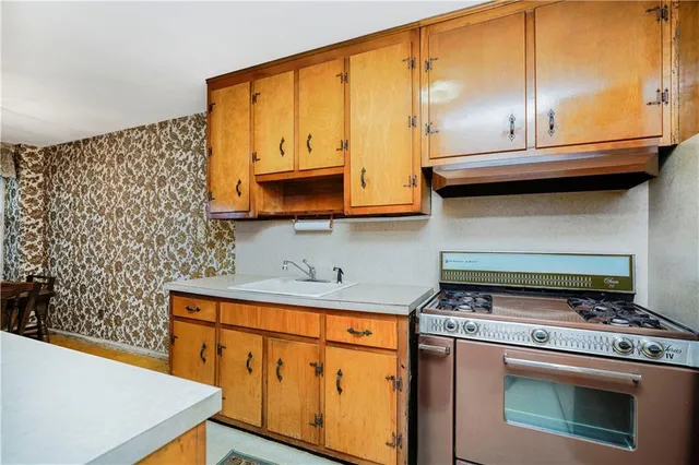 a stove top oven sitting inside of a kitchen